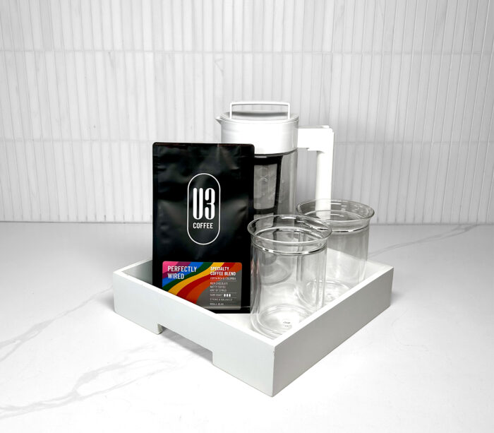 Gift Tray including 12 oz bag of U3 Perfectly Wired whole bean coffee, white Takeya cold brew coffee maker, Fellow Stagg Tasting Glasses on a white serving tray.